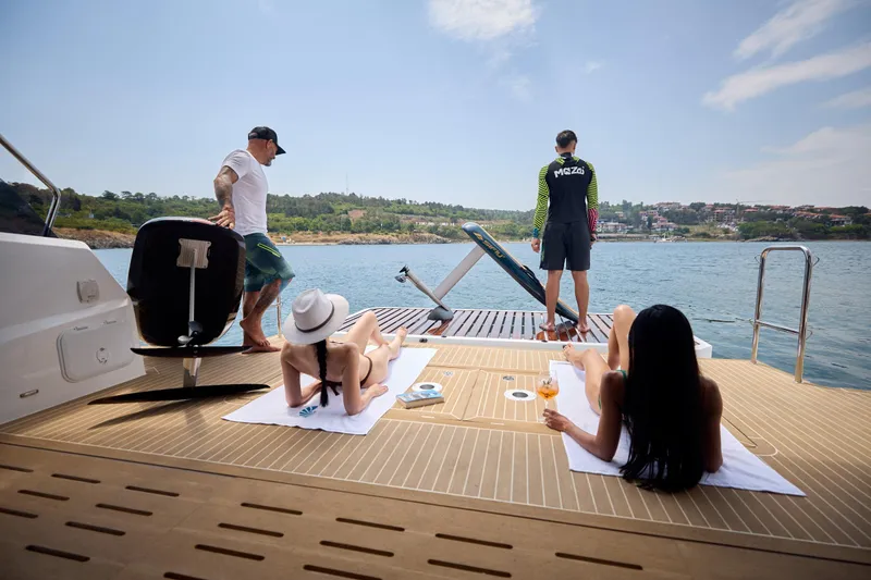 Slide: The Image of People relaxing on the deck of a 2025 Omaya 50 Power Catamaran, enjoying the sea view. - 34