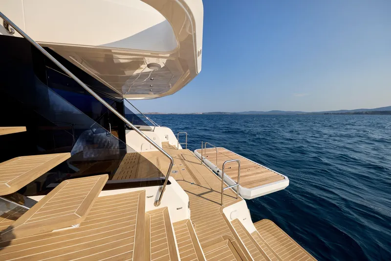 Slide: The Image of Luxurious 2025 Custom Omaya 50 Power Catamaran with teak deck, overlooking serene ocean waters. - 28