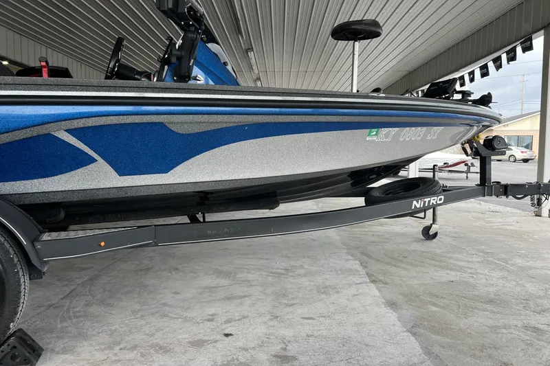 Slide: The Image of 2018 Nitro Z18 boat on trailer, featuring sleek blue and silver design under a covered area. - 3