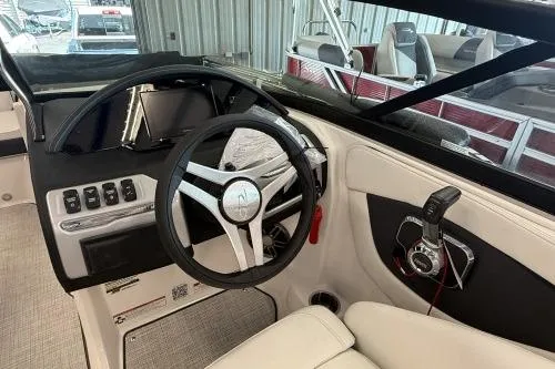 Slide: The Image of 2027 Regal 2000 ES boat interior with steering wheel and control panel in a marina setting. - 6