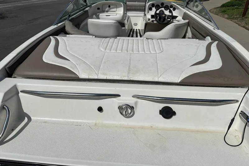 Slide: The Image of 1995 Mariah 180 Shabah boat interior with white and brown seating, steering wheel, and dashboard. - 4
