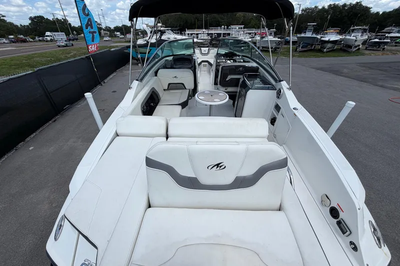 Slide: The Image of 2015 Monterey 288SS Super Sport boat interior with seating and helm, parked at a marina. - 13