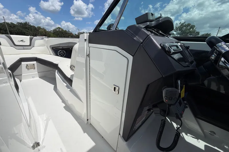 Slide: The Image of 2015 Monterey 288SS Super Sport boat interior with helm and seating under a blue sky. - 49