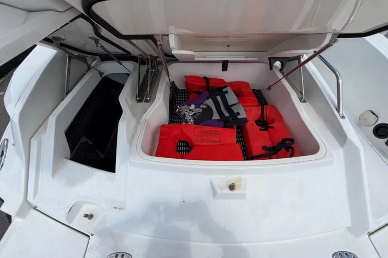 Slide: The Image of Open storage compartment on 2015 Monterey 288SS Super Sport boat with life jackets inside. - 16