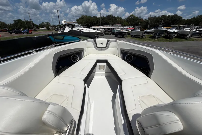 Slide: The Image of 2015 Monterey 288SS Super Sport boat interior with white seating and speakers, docked under a blue sky. - 51
