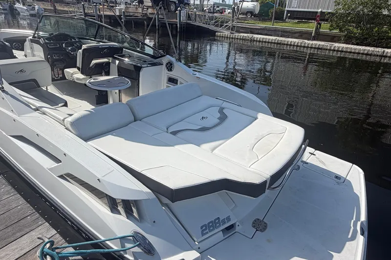 Slide: The Image of 2015 Monterey 288SS Super Sport boat docked at marina, featuring sleek white seating. - 11
