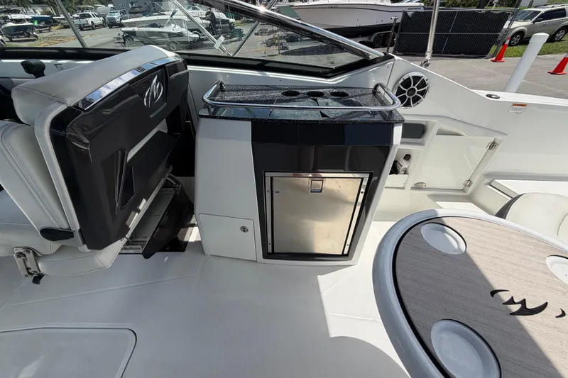 Slide: The Image of Interior of a 2015 Monterey 288SS Super Sport boat featuring seating and a compact kitchenette. - 22