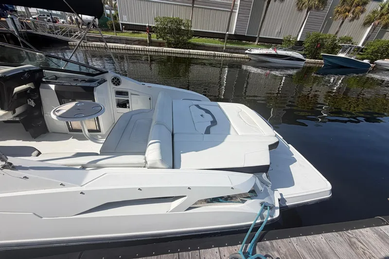Slide: The Image of 2015 Monterey 288SS Super Sport boat docked, featuring sleek white seating and modern design. - 10