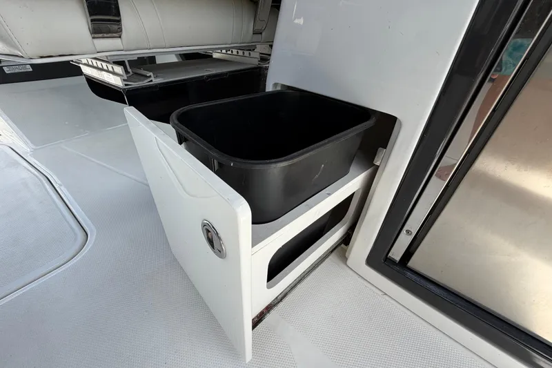Slide: The Image of Storage compartment with black bin on 2015 Monterey 288SS Super Sport boat. - 27