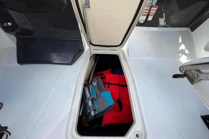 Slide: The Image of Open storage compartment on a 2015 Monterey 288SS Super Sport boat with life jackets inside. - 30