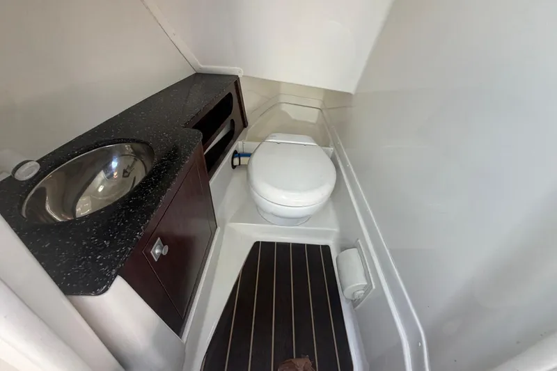 Slide: The Image of Compact bathroom in 2015 Monterey 288SS Super Sport boat with sink and toilet. - 19