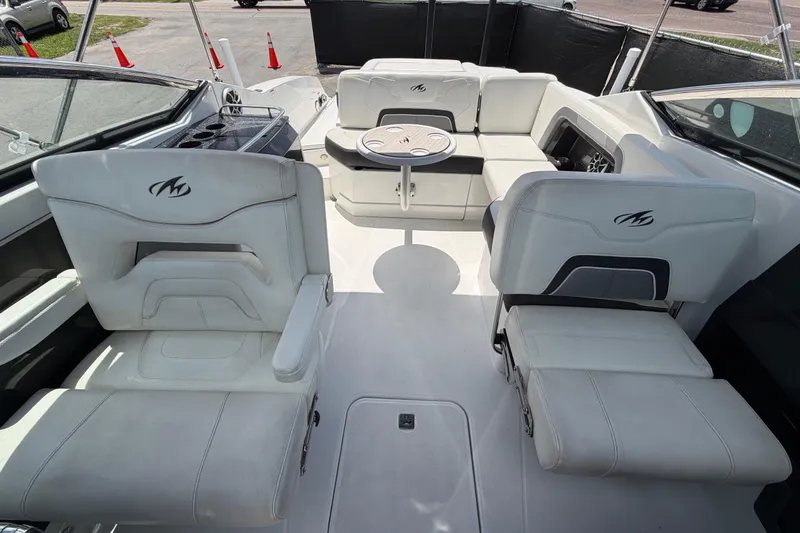 Slide: The Image of Interior of a 2015 Monterey 288SS Super Sport boat with white seating and table. - 58