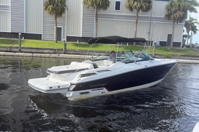 Slide: The Image of 2015 Monterey 288SS Super Sport boat cruising on a calm waterway near a dock. - 4