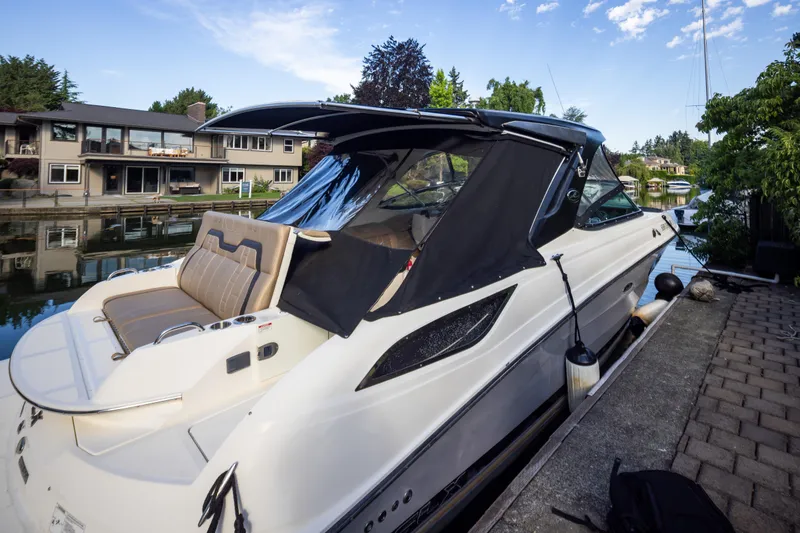 Slide: The Image of 2016 Sea Ray SLX 350 boat docked by waterfront homes under a clear sky. - 26