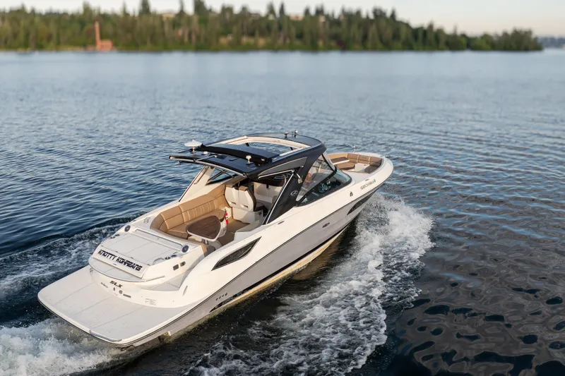 Slide: The Image of 2016 Sea Ray SLX 350 cruising on a serene lake with lush green shoreline. - 3