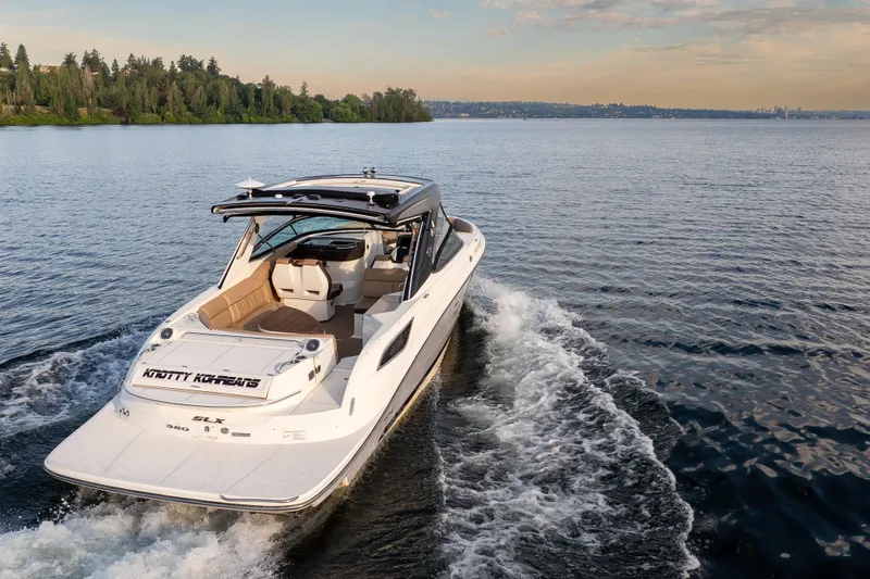 Slide: The Image of 2016 Sea Ray SLX 350 cruising on a serene lake with lush shoreline. - 4