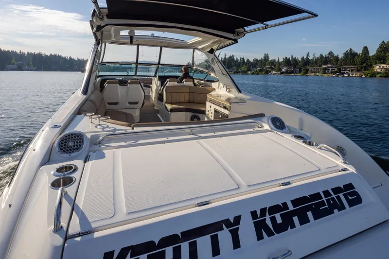 Slide: The Image of 2016 Sea Ray SLX 350 boat cruising on a serene lake with scenic shoreline. - 24