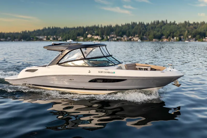 Slide: The Image of 2016 Sea Ray SLX 350 cruising on a serene lake with a forested shoreline. - 2