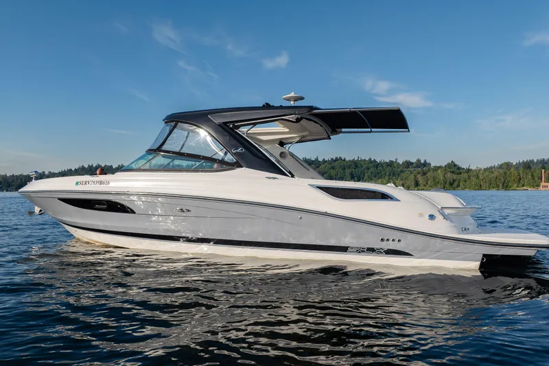 Slide: The Image of 2016 Sea Ray SLX 350 boat cruising on a serene lake under a clear blue sky. - 5