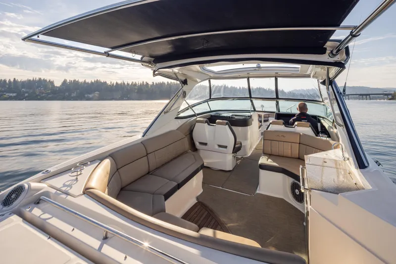 Slide: The Image of 2016 Sea Ray SLX 350 boat interior with seating and helm, cruising on calm waters. - 20