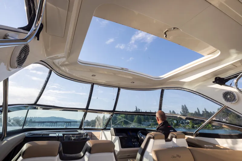 Slide: The Image of Interior view of 2016 Sea Ray SLX 350 boat with open sunroof and scenic waterway. - 23