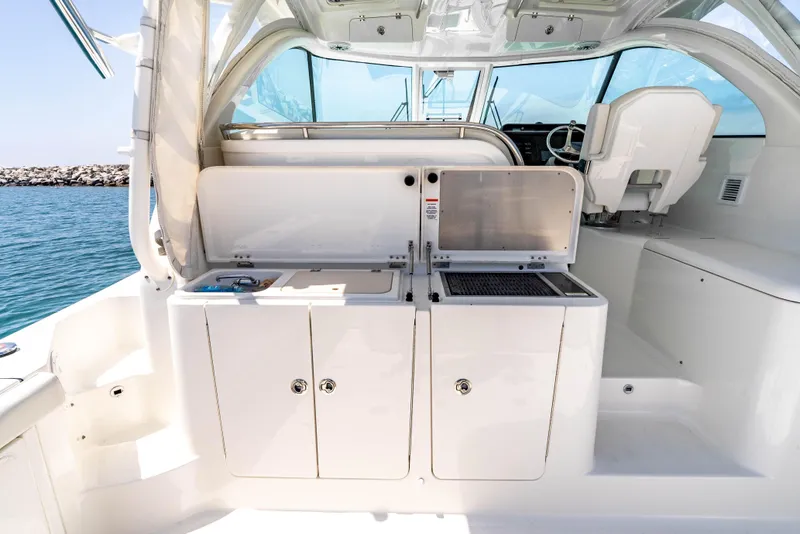 Slide: The Image of 2022 Pursuit OS 385 Offshore boat interior with open storage compartments and seating. - 14