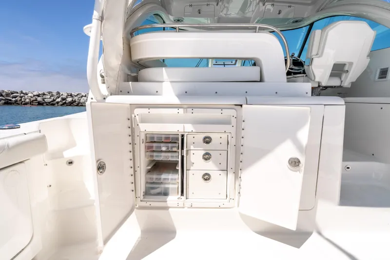Slide: The Image of 2022 Pursuit OS 385 Offshore boat interior with storage compartments open. - 13