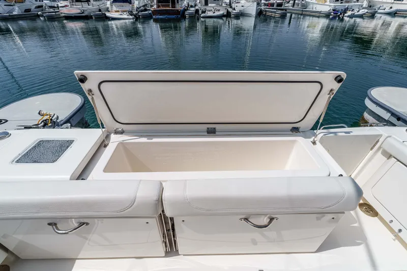 Slide: The Image of 2022 Pursuit OS 385 Offshore boat with open storage compartment at marina. - 20