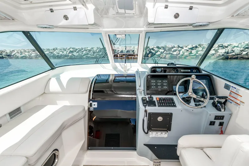 Slide: The Image of 2022 Pursuit OS 385 Offshore helm with modern controls and panoramic ocean view. - 17