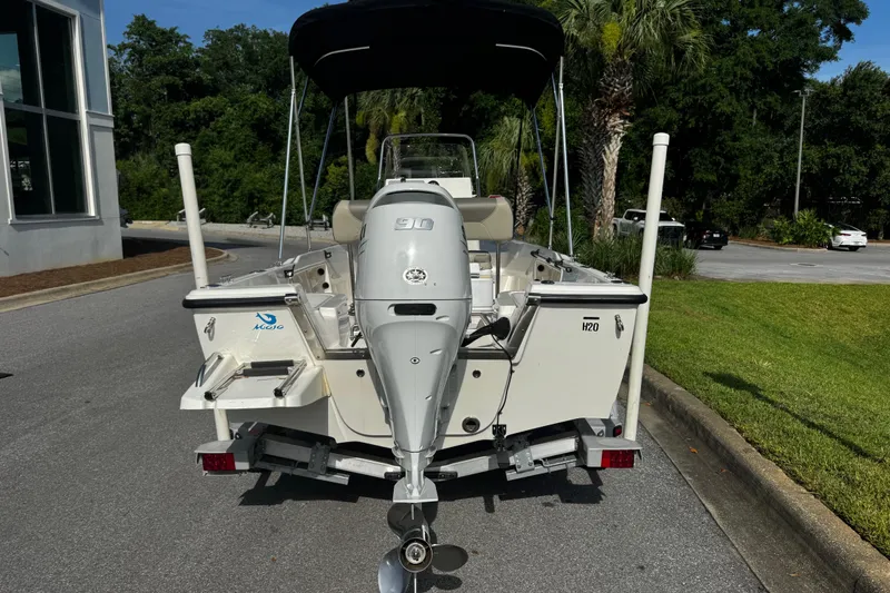 Slide: The Image of 2023 Key West 1720 Center Console boat with outboard motor, parked on a trailer. - 2