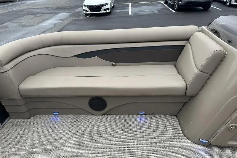 Slide: The Image of 2019 Bennington 20 SLM pontoon boat interior with beige seating and blue LED lights. - 17