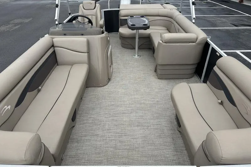 Slide: The Image of 2019 Bennington 20 SLM pontoon boat interior with beige seating and table. - 18