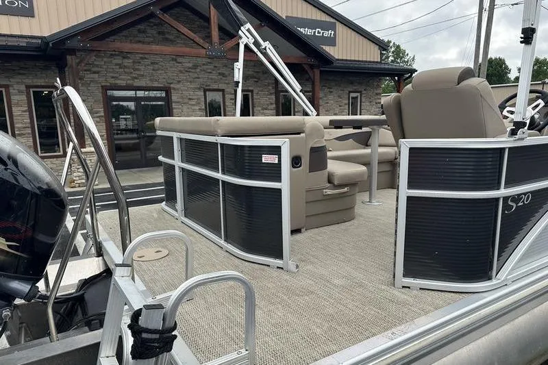 Slide: The Image of 2019 Bennington 20 SLM pontoon boat with beige seating, parked outside a dealership. - 6