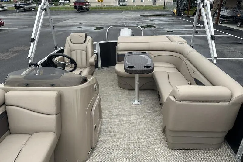 Slide: The Image of 2019 Bennington 20 SLM pontoon boat interior with beige seating and table. - 10