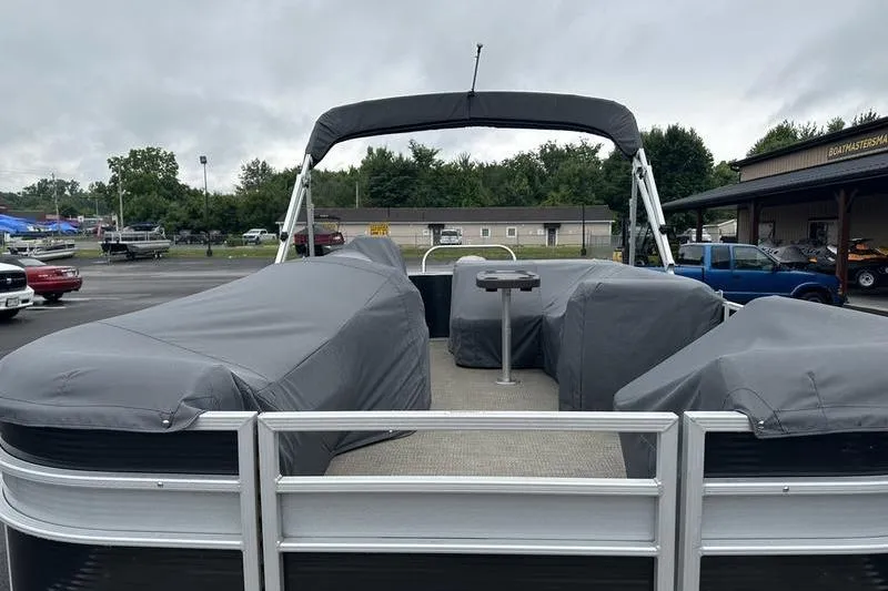 The Image of 2019 Bennington 20 SLM pontoon boat with covered seating, parked outdoors. - 1