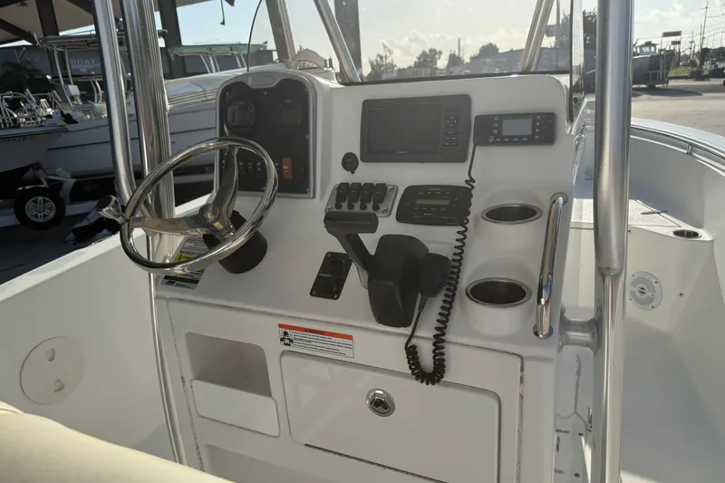 Slide: The Image of 2015 Sea Hunt Triton 225 boat console with steering wheel and navigation controls. - 10