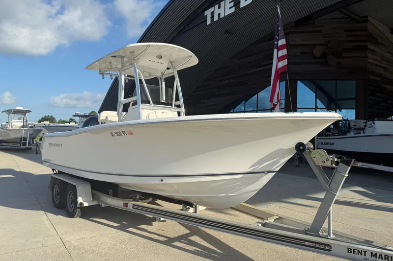 Slide: The Image of 2015 Sea Hunt Triton 225 boat on trailer, parked outside a marina. - 3