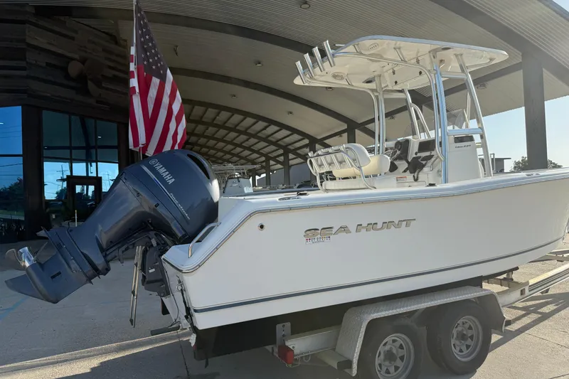 Slide: The Image of 2015 Sea Hunt Triton 225 boat on trailer with Yamaha outboard motor and American flag. - 9