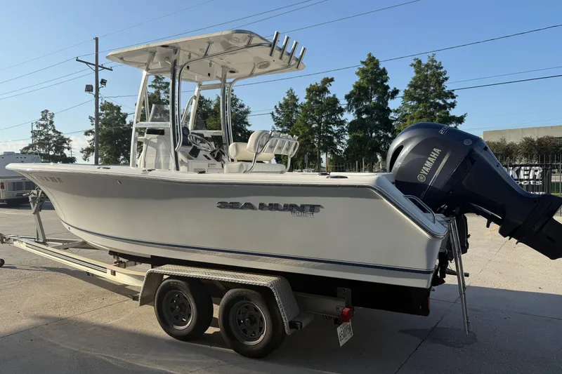 Slide: The Image of 2015 Sea Hunt Triton 225 boat on trailer with Yamaha engine, parked outdoors. - 7