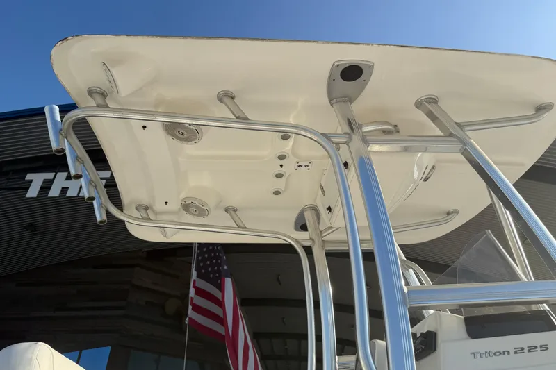 Slide: The Image of 2015 Sea Hunt Triton 225 boat with T-top and American flag in background. - 14