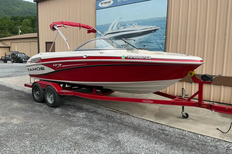 Slide: The Image of Red 2014 Tahoe Q7i boat on trailer, parked outside a building. - 2