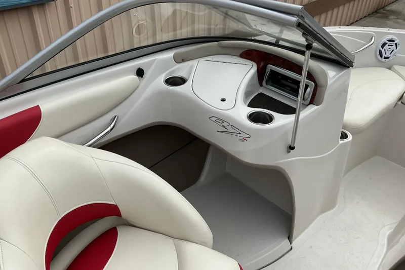 Slide: The Image of Interior of a 2014 Tahoe Q7i boat featuring white and red seating and dashboard controls. - 5
