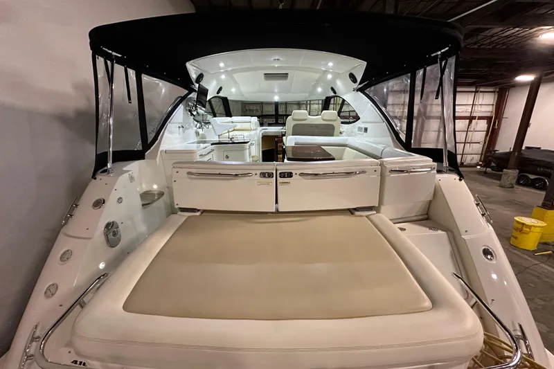 Slide: The Image of 2014 Sea Ray 410 Sundancer yacht interior with seating and canopy in a warehouse setting. - 3