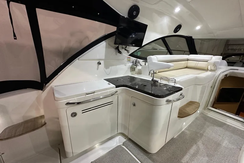 Slide: The Image of Interior of 2014 Sea Ray 410 Sundancer yacht with seating, kitchenette, and TV. - 8
