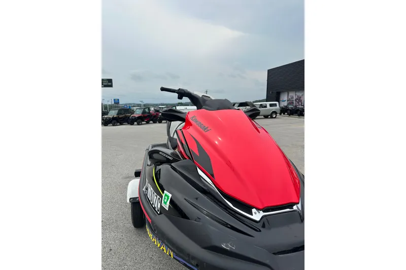 Slide: The Image of 2024 Kawasaki Jetski STX 160LX in vibrant red, parked outdoors on a cloudy day. - 6