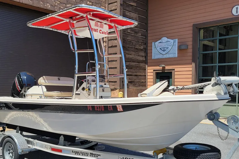Slide: The Image of 2021 Carolina Skiff 178 JLS boat on trailer, featuring red canopy and Mercury engine. - 3
