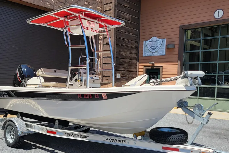 The Image of 2021 Carolina Skiff 178 JLS boat on trailer outside marina service entrance. - 0