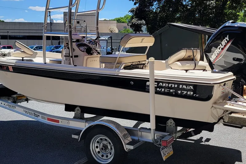 Slide: The Image of 2021 Carolina Skiff 178 JLS boat on trailer, featuring a Mercury engine. - 4