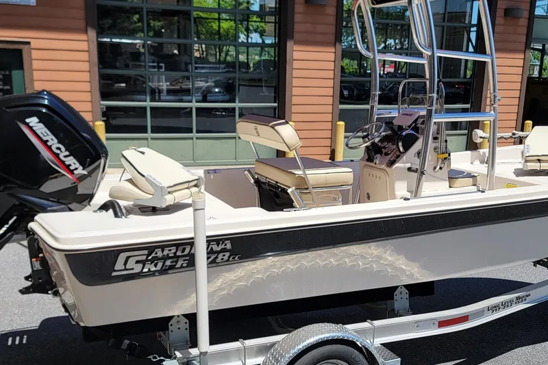 Slide: The Image of 2021 Carolina Skiff 178 JLS boat with Mercury engine on trailer, parked outdoors. - 1
