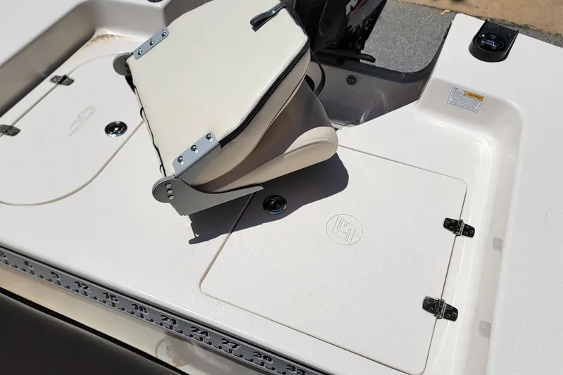 Slide: The Image of 2021 Carolina Skiff 178 JLS boat interior with foldable seat and storage compartments. - 11